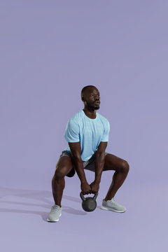 Fitness Training. Sports Man Doing Kettlebell Squat Workout