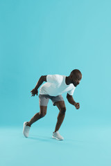 Fototapeta na wymiar Sport. Man runner in running start pose, preparing to run