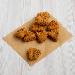 Fried camembert on a baking sheet on a white wooden surface, low angle view. Close-up.