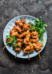 Teriyaki marinated duck skewers on a dark background, top view. Delicious snack, tapas, appetizers