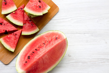 Slices of fresh watermelon on bamboo board, overhead view. Top view, from above. Copy space.