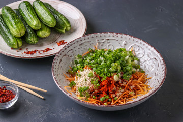 Preparing products for cooking traditional Korean cucumber kimchi snack: mixing ingredients in a bowl, fermented food, horizontal photo