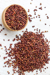 Box with red millet and millet grain on a white background