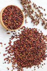 Box with red millet and millet grain on a white background