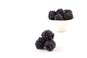 Blackberries berries on a saucer isolated on a white background.