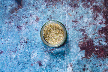 Fototapeta na wymiar Ubtan. Herbs wash for face skin.In a glass jar on a blue background.