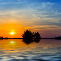 Fototapeta na wymiar dramatic sunset above the prairie reflected in a water