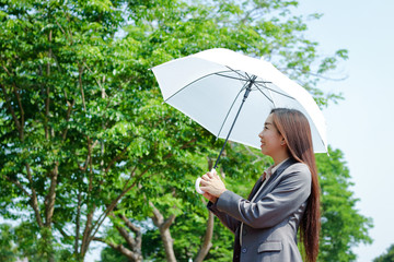 Asian girl working in the office She held a parasol in the hot weather.