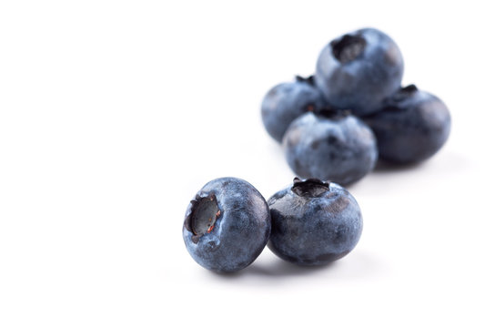 A group of blueberries on a white background, two blueberry berry in the foreground. Close up.