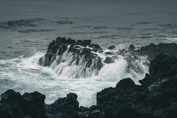 Azores, Big waves crashing over black volcanic rock on the Atlantic Ocean in the coast of Sao Miguel island in the Azores, Portugal