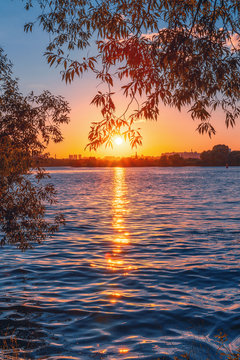 Sunset on the shore. The reflection of the sun in the water. Strogino