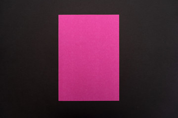 Blank bright pink paper sheet on black background. Layout for business, posters and banners.