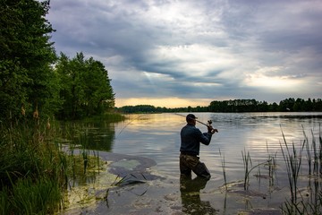 angler catching the fish during overcast day
