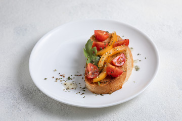 Italian bruschetta with tomatoes on a white plate against white background. View from above