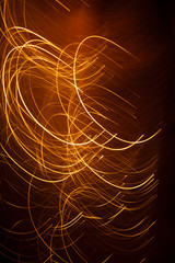 Abstract background orange stripes from sparks on a dark background.