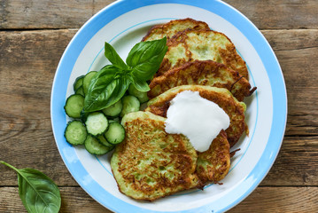 Zucchini fritters with sour cream, cucumbers and basil