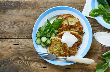 Zucchini fritters with sour cream, cucumbers and basil