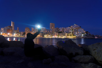 Fototapeta na wymiar man with lantern at Finestrat's Cala beach at night
