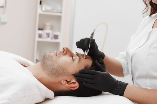 The cosmetologist makes the procedure Microdermabrasion