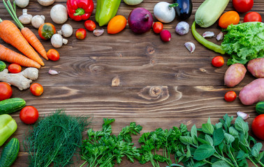 On a brown wooden background fresh vegetables from the garden, for a healthy diet.