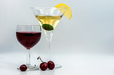 Martini with olive and lemon slice. Red wine in a glass. A slice of lemon and cherry as a decoration for a drink.