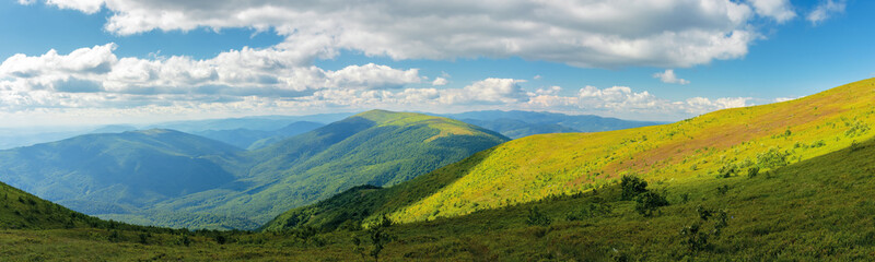beautiful panorama of a summer landscape. grassy hills and distant ridges, amazing scenery in mountains. sunny weather with cloudy sky on a windy day. picturesque view in to the horizon