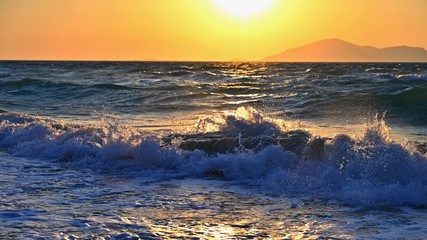 Fototapeta premium Beautiful sunset with sea and waves. Natural colorful background. Concept for summer and sea vacation. Greece - island of Kos.