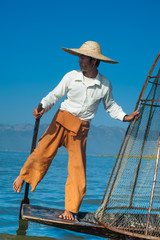 Burmese fisherman on bamboo boat catching fish. Myanmar