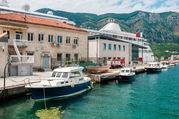 Boats in the water at harbor in the ancient town Kotor surrounded by mountains, Montenegro