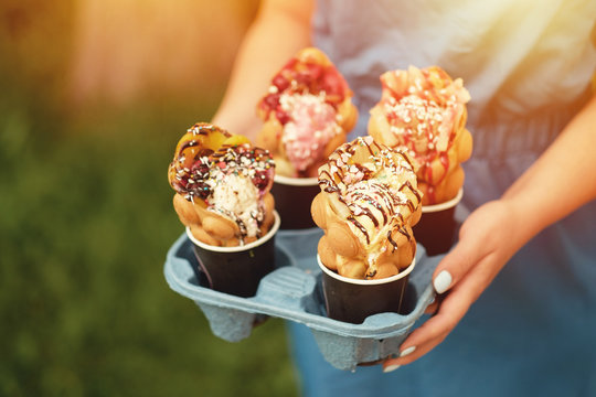 Four Hong Kong Waffles In Cups Food Delivery In Hand Of Woman