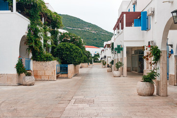 White houses with blue shutters in the street at Budva city, Montenegro