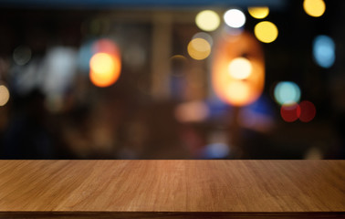 Empty dark wooden table in front of abstract blurred bokeh background of restaurant . can be used for display or montage your products.Mock up for space.