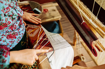 Young woman hands working on Vintage wooden weaving loom with silk fiber - 279485722