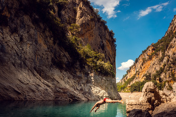 Mann springt in das Wasser einer Schlucht in den Pyrenäen 