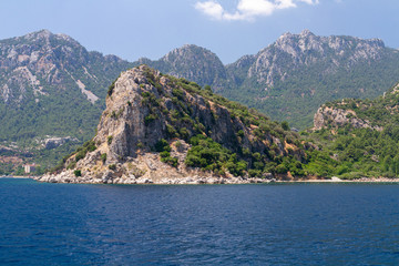 Scenic view of the Aegean Islands. The unique shades of the sea and the rocks covered with pine trees.