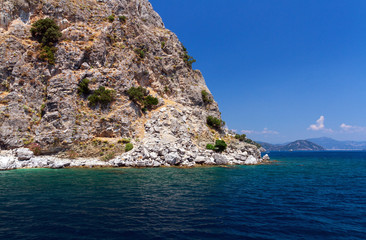 Scenic view of the Aegean Islands. The unique shades of the sea and the rocks covered with pine trees.