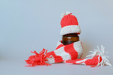  a bottle of syrup dressed in a scarf and cap in the season of colds