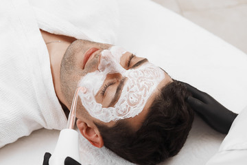 Face of beauty clinic customer. Man having darsonval therapy.
