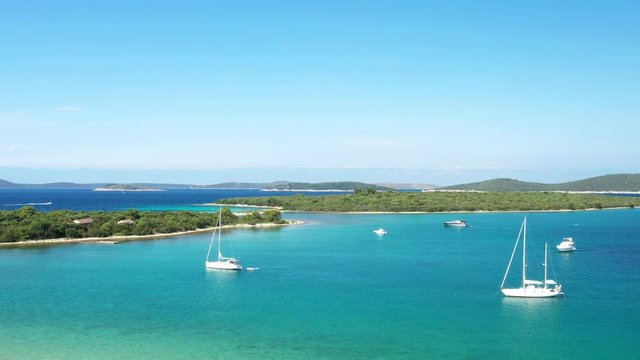 Drone flight over beautiful seascape on Adriatic sea in Croatia, Dugi otok island archipelago, sailing boats on seashore in blue bay lagoon 