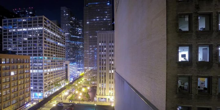 Timelapse of the Chicago, Illinois Cityscape at Night, Next to an Empty Office Building while Trains and Cars Pass on the Streets Below