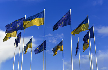 Flags of Ukraine and EU on sky background