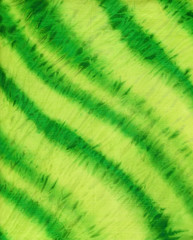 Abstract hand painted yellow green  shibori fabric background with irregular stripes