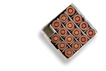 Open box of gun cartridges on isolated background. One cell is empty as a concept of used bullet. Closeup image of ammo