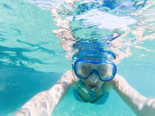 Fototapeta premium woman taking a selfie snorkeling in clear tropical waters - active holiday