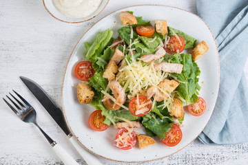 Traditional Italian Caesar salad with chicken, tomatoes and Parmesan