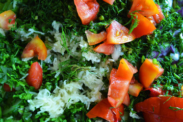 Useful and tasty vegetables, finely sliced ​​red tomatoes, green dill, blue onion and garlic for summer salad, salad ingredients.