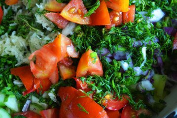 Useful and tasty vegetables, finely sliced ​​red tomatoes, green dill, blue onion and garlic for summer salad, salad ingredients.