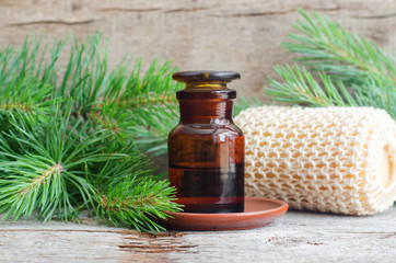 Apothecary bottle with essential pine oil (extract, tincture, infusion). Old wooden background. Aromatherapy, spa and herbal medicine concept. Copy space.