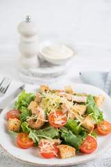 Traditional Italian Caesar salad with chicken, tomatoes and Parmesan