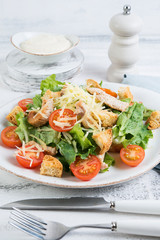 Traditional Italian Caesar salad with chicken, tomatoes and Parmesan